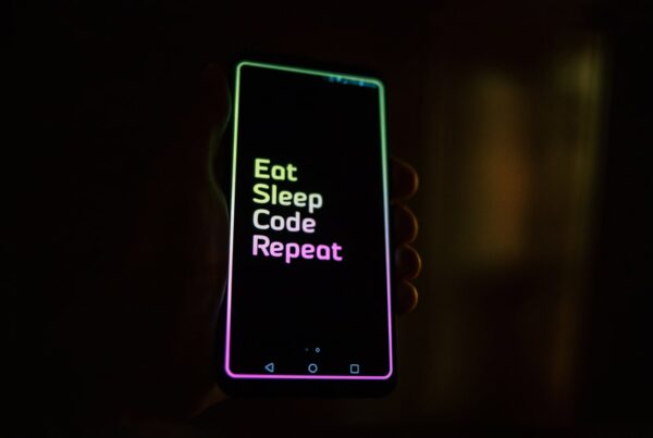 Mobile phone with 'Eat, Sleep, Code, Repeat' message on it