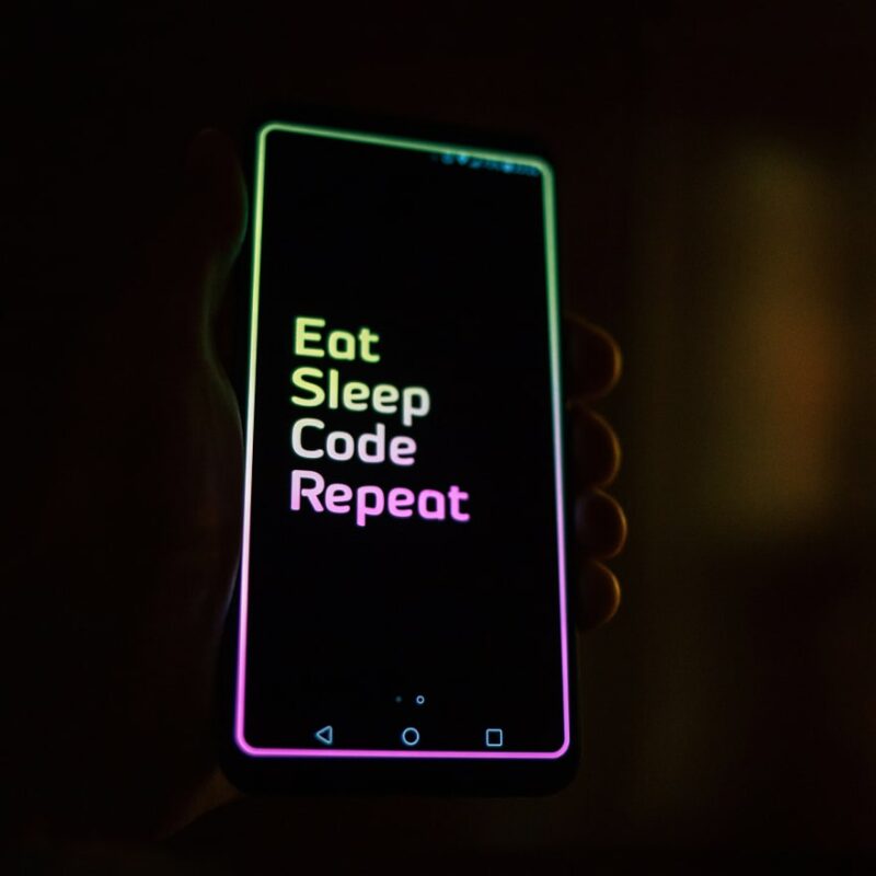 Mobile phone with 'Eat, Sleep, Code, Repeat' message on it